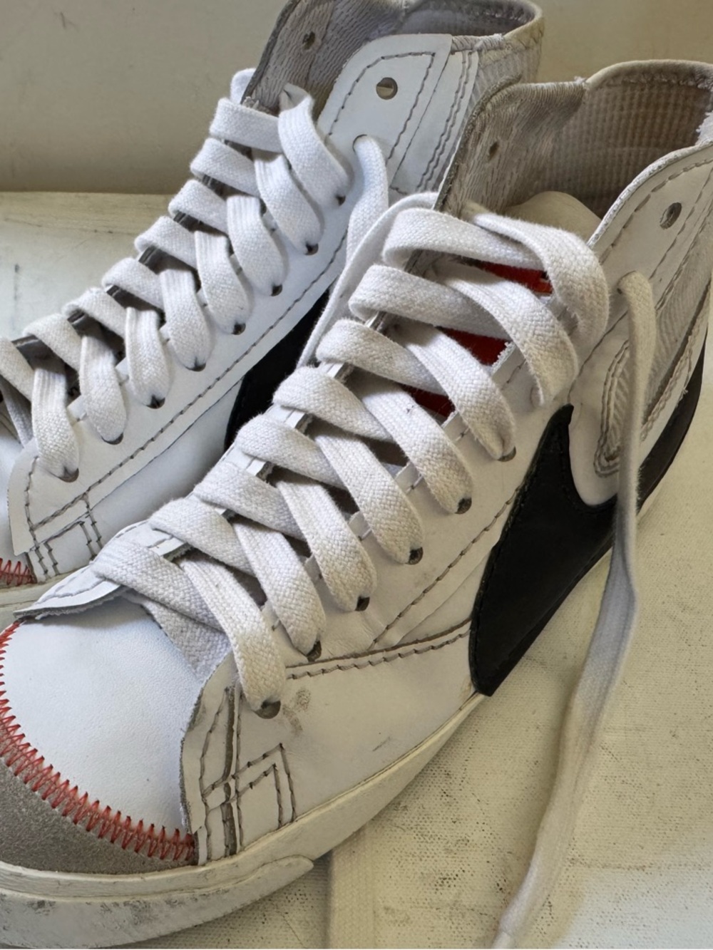 Nike White High-Top Sneakers with Black Swoosh and Red Stitching